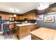 Well-lit kitchen with breakfast bar, wood cabinets, tile floors, and unique light fixtures at 300 N Fulton St # 12, Salisbury, NC 28144