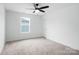 A simple bedroom features neutral walls, carpet, a ceiling fan, and natural light at 3030 Swallowtail Ln, Kannapolis, NC 28083