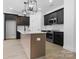 Well-equipped kitchen with dark cabinetry, white backsplash, and a functional center island at 3030 Swallowtail Ln, Kannapolis, NC 28083