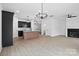 Open-concept living room featuring hardwood floors, modern lighting and a cozy fireplace at 3030 Swallowtail Ln, Kannapolis, NC 28083