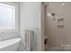 Bright bathroom with white soaking tub, walk-in shower, and gray tiling at 4009 Beechwood Spring Ln, Belmont, NC 28012