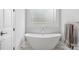 Modern white soaking tub with chrome faucet, large window and tile flooring at 4009 Beechwood Spring Ln, Belmont, NC 28012