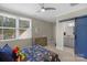 Well-lit bedroom with a sliding barn door to the bathroom and a large window with a ceiling fan at 4009 Beechwood Spring Ln, Belmont, NC 28012
