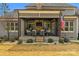 Cozy covered patio with stone fireplace, comfortable seating, and an American flag at 4009 Beechwood Spring Ln, Belmont, NC 28012