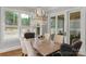 Elegant dining room with chandelier lighting, large windows, and a wooden table set for six at 4009 Beechwood Spring Ln, Belmont, NC 28012