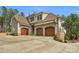 Spacious three-car garage with elegant wooden doors and stone accents at 4009 Beechwood Spring Ln, Belmont, NC 28012
