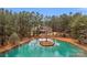 Scenic view of a home nestled near a tranquil pond, surrounded by tall pine trees at 4009 Beechwood Spring Ln, Belmont, NC 28012
