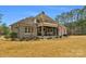 Beautiful home exterior with a covered patio, stone accents, and lush landscaping at 4009 Beechwood Spring Ln, Belmont, NC 28012