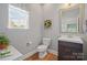 Neutral-toned bathroom featuring a wooden floor, vanity with sink, toilet and a window at 4035 W Sandy Trl, Fort Mill, SC 29707