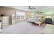 Light-filled main bedroom featuring a ceiling fan, dresser and large windows at 4035 W Sandy Trl, Fort Mill, SC 29707