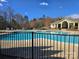 Large community pool with a clubhouse in the background surrounded by a fence at 4035 W Sandy Trl, Fort Mill, SC 29707