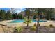 Community pool surrounded by lush trees, tropical plants, and lounge furniture at 4035 W Sandy Trl, Fort Mill, SC 29707