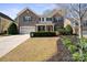 Charming two-story home featuring a stone facade, red door, well-manicured lawn, and an attached two-car garage at 4035 W Sandy Trl, Fort Mill, SC 29707