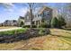 Charming two-story home featuring a stone facade, red door, well-manicured lawn, and mature trees at 4035 W Sandy Trl, Fort Mill, SC 29707