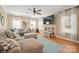 Bright living room features a large sectional, decorative mantel, and a view of the backyard through the windows at 4035 W Sandy Trl, Fort Mill, SC 29707