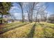 Expansive backyard with mature trees and lush lawn, providing a serene outdoor setting at 4136 Woodgreen Ter, Charlotte, NC 28205
