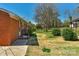 Sideyard view of a brick home with lush backyard offering privacy and greenery at 602 Dallas Spencer Mountain Rd, Dallas, NC 28034