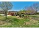 Spacious backyard view of a brick home with mature trees and covered patio, perfect for relaxing at 602 Dallas Spencer Mountain Rd, Dallas, NC 28034