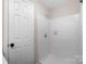 Bathroom featuring a tiled shower with a shower head and a white door at 6134 Meadow Rose Ln, Charlotte, NC 28215