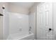 Bathroom featuring a white tub with white tiled walls and a shower head at 6134 Meadow Rose Ln, Charlotte, NC 28215