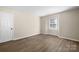 Large bedroom featuring neutral walls, wood-look floors, and a window at 6134 Meadow Rose Ln, Charlotte, NC 28215