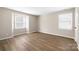 Bedroom featuring two windows, neutral walls, and wood-look flooring at 6134 Meadow Rose Ln, Charlotte, NC 28215
