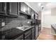 Close up of the modern kitchen featuring black cabinets, granite countertops, and stainless steel appliances at 6134 Meadow Rose Ln, Charlotte, NC 28215