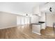 Bright open living room with hardwood-style floors, ceiling fan, and modern kitchen view at 6134 Meadow Rose Ln, Charlotte, NC 28215