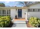 Close-up of a blue front door with brick steps, lush landscaping, and a welcoming entrance at 6136 Montpelier Rd, Charlotte, NC 28210