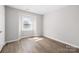 Sunlit bedroom with wood-look floors and a window at 6142 Meadow Rose Ln, Charlotte, NC 28215