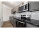 Updated kitchen with stainless steel oven, range, microwave, and dark countertop at 6142 Meadow Rose Ln, Charlotte, NC 28215