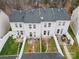 Aerial view of townhome backyards featuring patios, grass, and white privacy fences at 6936 Colonial Garden Dr, Huntersville, NC 28078