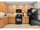 Well-equipped kitchen with sleek black appliances, granite countertops, and warm-toned cabinetry for a classic look at 6936 Colonial Garden Dr, Huntersville, NC 28078