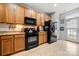 Well-equipped kitchen with sleek black appliances, granite countertops, and warm-toned cabinetry for a classic look at 6936 Colonial Garden Dr, Huntersville, NC 28078