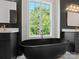 Elegant bathroom with a deep soaking tub, dual vanities, and a window offering a view to the trees outside at 733 Barbary Pl, Lincolnton, NC 28092