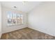Vaulted ceiling in cozy bedroom, neutral carpet, white trim, plantation shutters, and ample light at 7364 Laurel Valley Rd, Charlotte, NC 28273