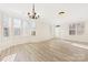 Large living room featuring shuttered windows and light wood laminate floors at 7364 Laurel Valley Rd, Charlotte, NC 28273