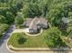 Stunning aerial view of a landscaped property with a circular driveway, mature trees, and lush green lawns at 7913 Buena Vista Dr, Denver, NC 28037