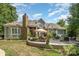 An inviting outdoor patio features a stone fireplace, dining set, and cozy seating area perfect for entertaining at 7913 Buena Vista Dr, Denver, NC 28037
