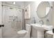 Modern bathroom with glass-enclosed shower, round mirror, and tiled walls at 7913 Buena Vista Dr, Denver, NC 28037