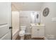 Well-lit bathroom featuring a toilet, shower, and vanity with a decorative mirror, alongside neutral paint at 7913 Buena Vista Dr, Denver, NC 28037