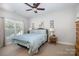 Relaxing bedroom featuring soft carpet, a ceiling fan, a comfortable bed, and natural light from the window at 7913 Buena Vista Dr, Denver, NC 28037