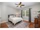 Cozy bedroom featuring hardwood floors, ceiling fan, and natural light from shuttered windows at 7913 Buena Vista Dr, Denver, NC 28037