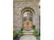 Elegant arched wood front door with stone surround, complemented by manicured landscaping and a welcoming entrance at 7913 Buena Vista Dr, Denver, NC 28037