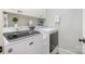 Practical laundry room with modern washer and dryer units and overhead storage cabinets at 7913 Buena Vista Dr, Denver, NC 28037