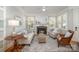Bright living room with a brick fireplace, white mantle, large windows, and stylish furnishings at 7913 Buena Vista Dr, Denver, NC 28037