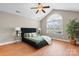 Spacious main bedroom with hardwood floors, large window, ceiling fan, and a tufted platform bed at 824 Wynnshire Dr # D, Hickory, NC 28601