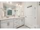 Bathroom featuring double sinks, a large mirror, modern lighting, and white cabinets at 9534 Liberty Hill Dr # 196, Mint Hill, NC 28227