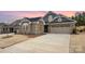 Charming home exterior showcasing a stone and gray facade, well-manicured lawn, and a spacious driveway at 9534 Liberty Hill Dr # 196, Mint Hill, NC 28227