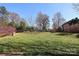 Expansive backyard showcasing vibrant green grass and bordered by mature trees at 1000 E Woodlawn Rd # 110, Charlotte, NC 28209